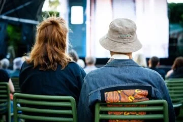 Audience members seated at an outdoor film screening.