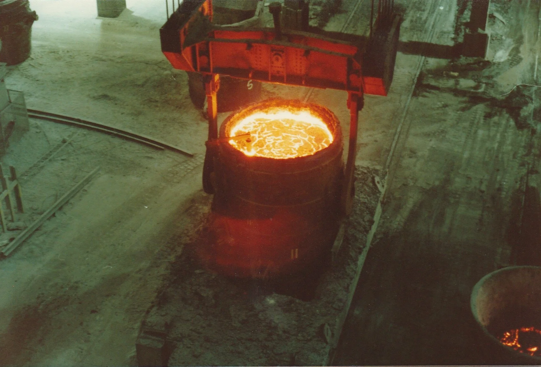 A ladle containing hot and orange melted steel