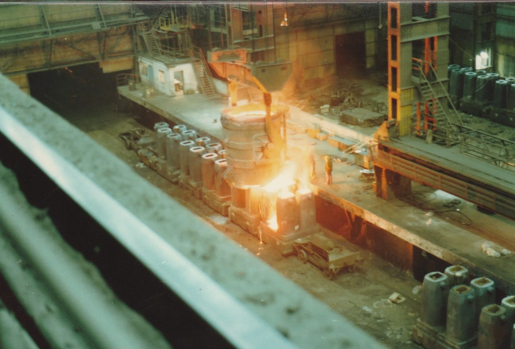 A ladle pouring melted steel into ingots