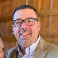 Podcaster Dan Cumberland wearing glasses and a white shirt