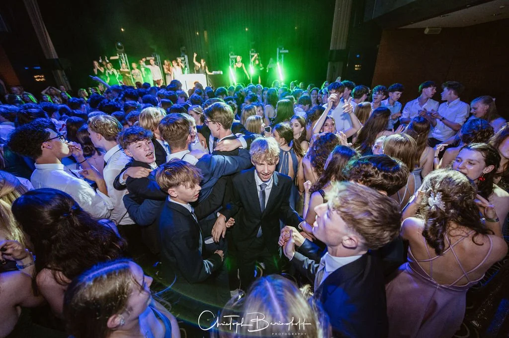 Viele Jugendliche tanzen und feiern auf einer Party mit einer Live-Band auf der Bühne