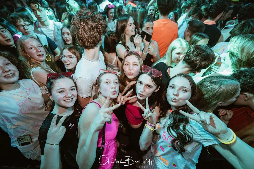 Young girls taking photos and having fun at a party or concert.