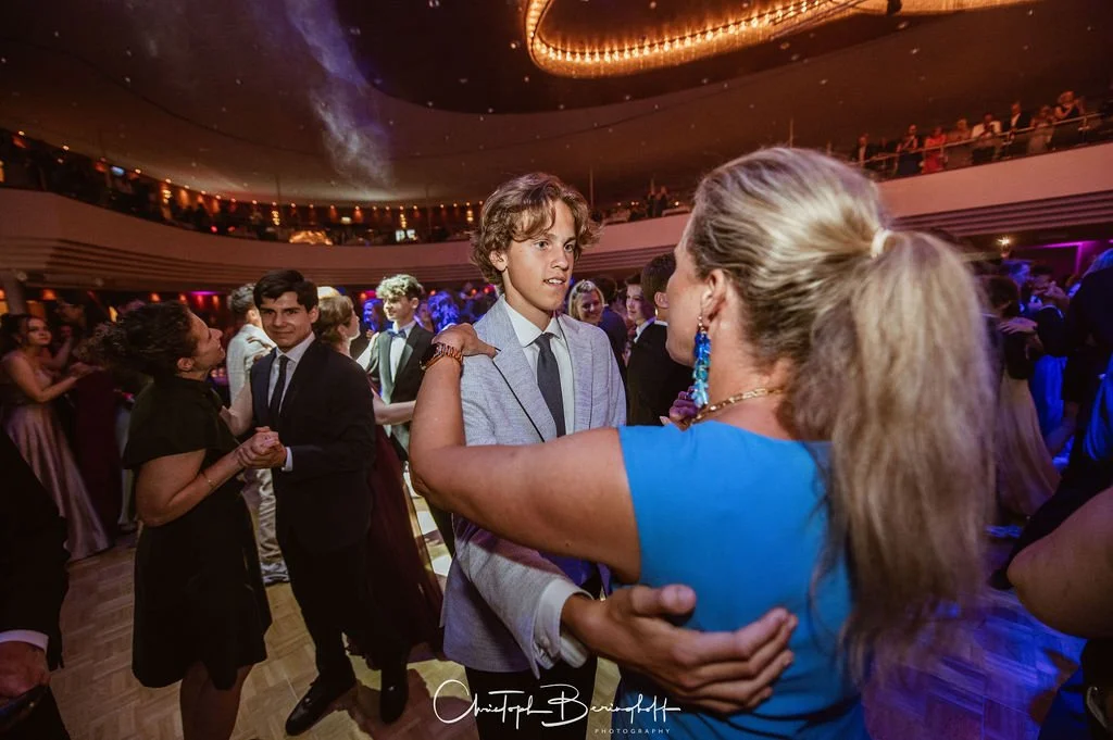 Jugendliche tanzen auf einem festlichen Ball im eleganten Saal.