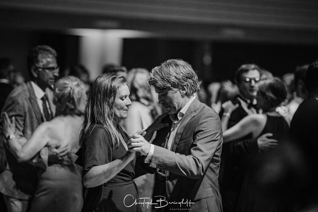 Paare tanzen auf einer Party in einem dunklen Raum, schwarz-weiß Fotografie.