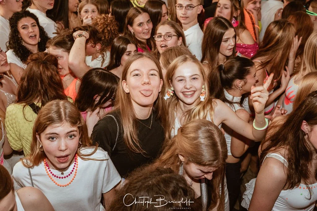 Many young women and girls at a party or event, laughing and having fun.