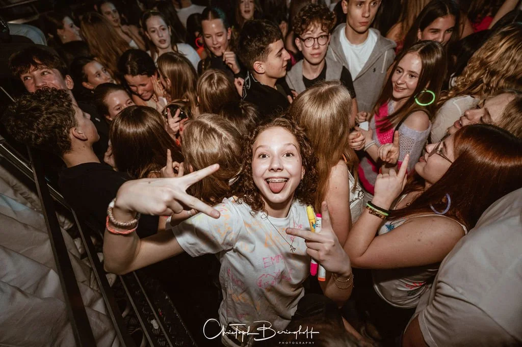 A group of young people at a party, happily posing and having fun.