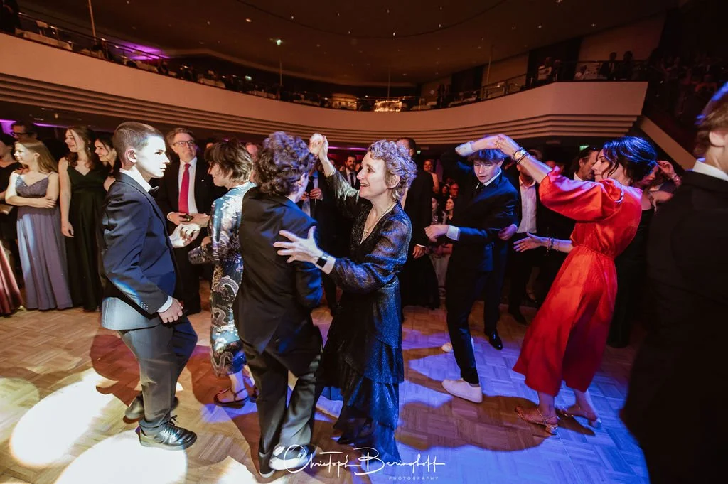 Menschen tanzen und feiern in einem festlichen Ballroom bei einer Veranstaltung oder Gala.