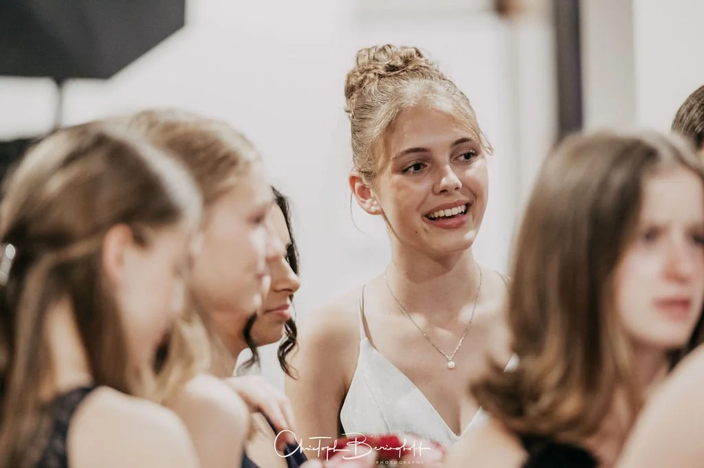 Eine Gruppe junger Frauen, eine spricht im Mittelpunkt, während die anderen zuhören.