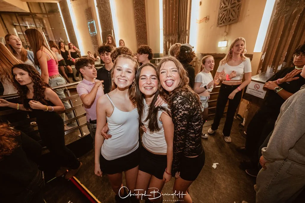 Young women and teenagers at a party in a club, laughing and having fun.