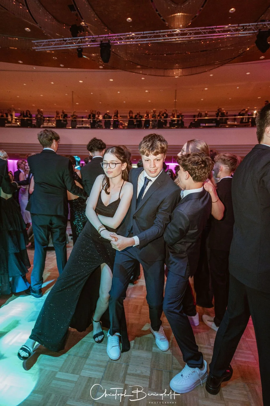 Jugendliche tanzen auf einer formellen Party oder Ball, tragen elegante Kleidung und haben Spaß auf der Tanzfläche.