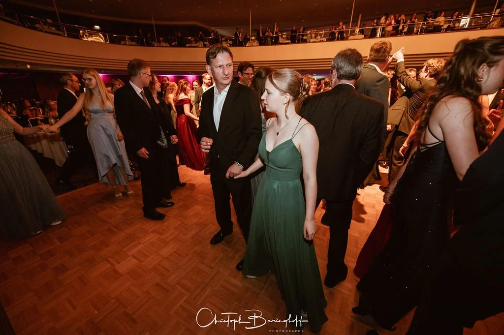 Menschen tanzen auf einer eleganten Gala in einem Ballsaal.