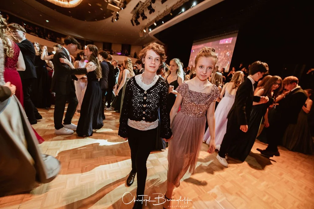 Jugendliche tanzen auf einem festlichen Ball im Saal.