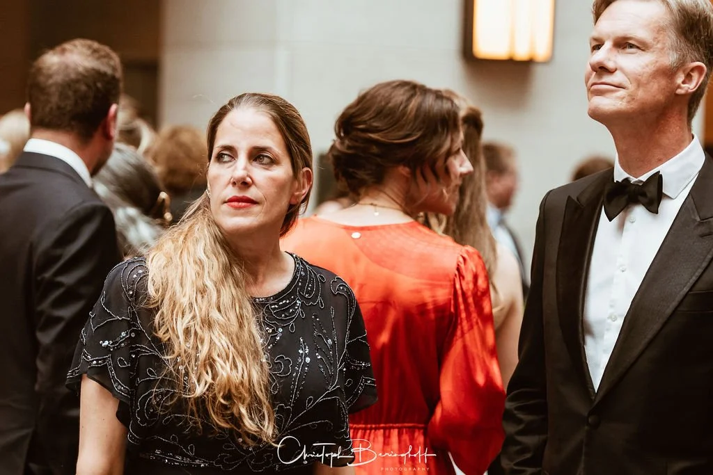 Menschen in formeller Kleidung auf einer Gala oder bei einer Veranstaltung.