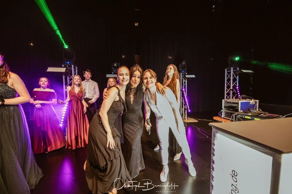 Junge Frauen feiern auf einer Party mit bunten Lichtern und Musik-Equipment.