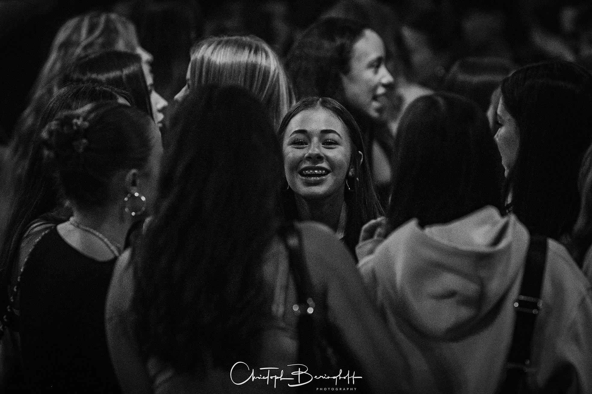 Gruppe von lachenden jungen Frauen in einem Kreis, Schwarz-Weiß-Foto.