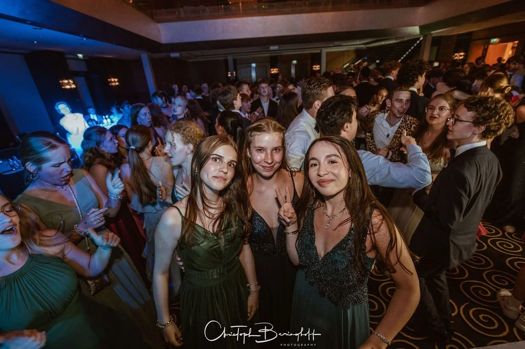 Junge Menschen tanzen und feiern auf einer Party im Saal.