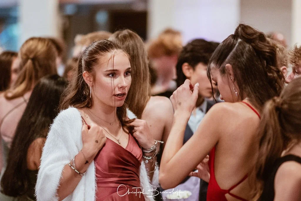 Junge Frauen auf einer Party, die miteinander sprechen.