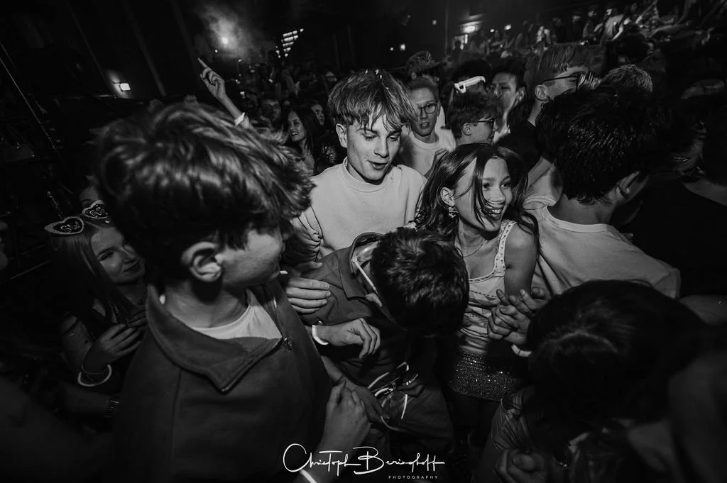 People dancing and having fun at a party or concert; black-and-white photo.