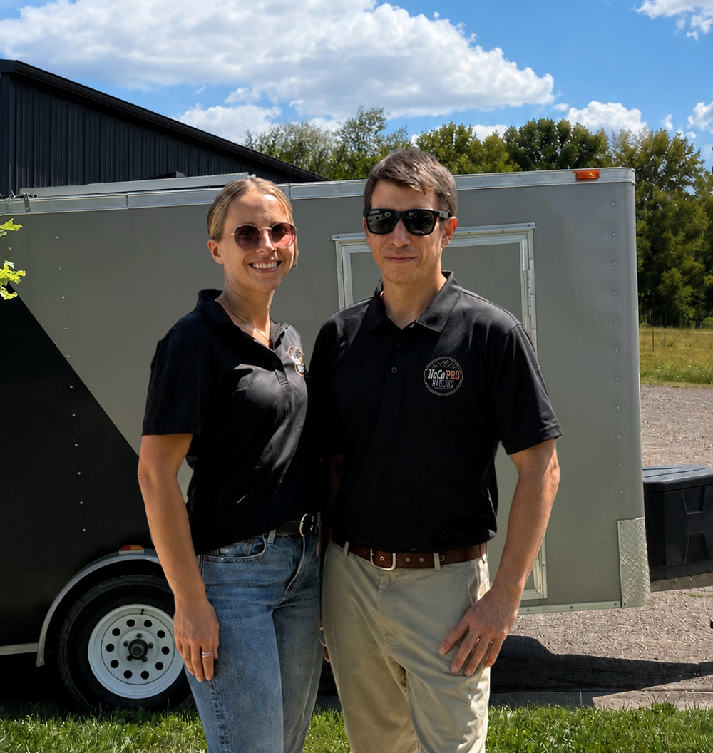Brenden and Alison of NoCo Pro Hauling standing beside their enclosed trailer.