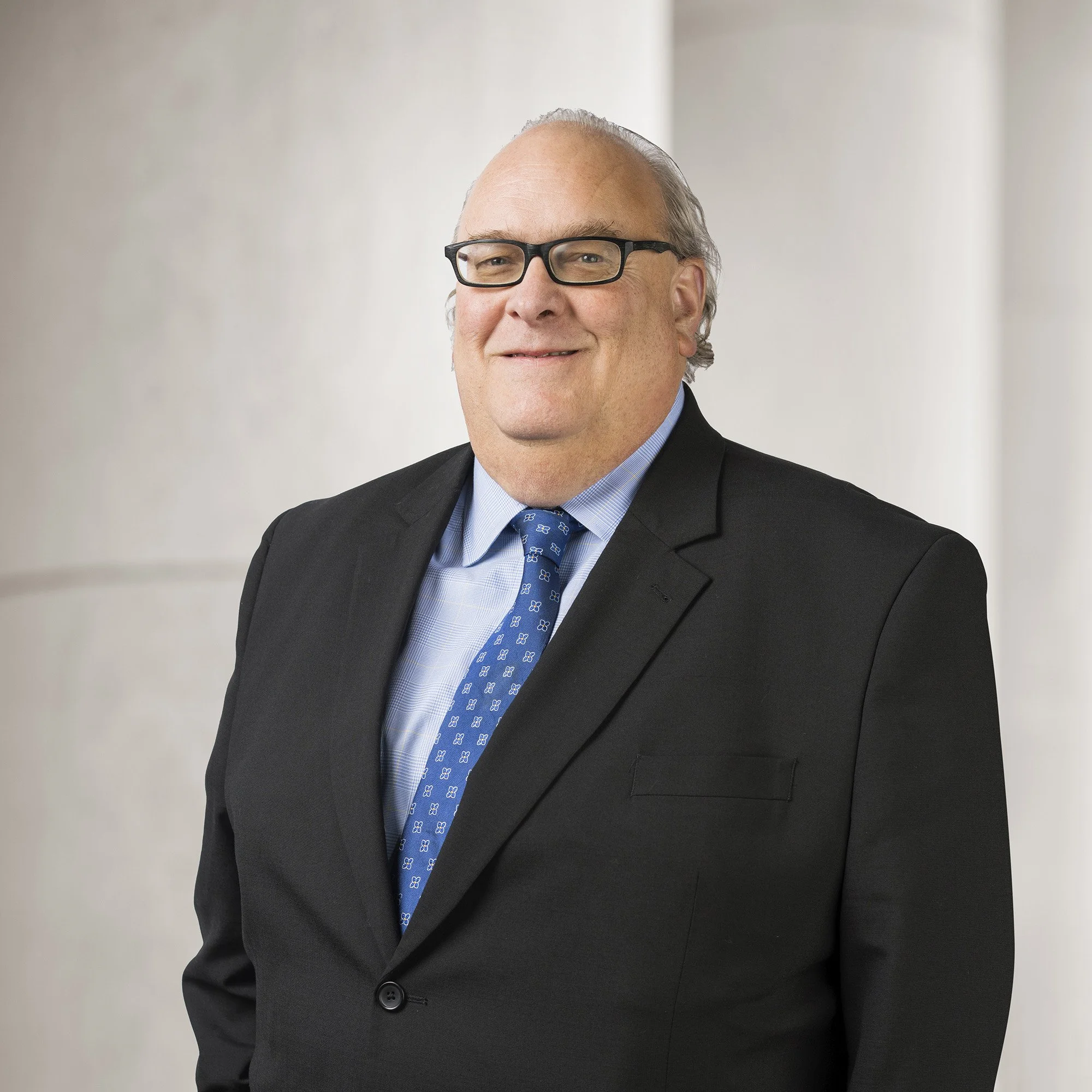 Portrait of Nick Bate, Director of Client Relations at Baughman Kroup Bosse, on courthouse steps. 