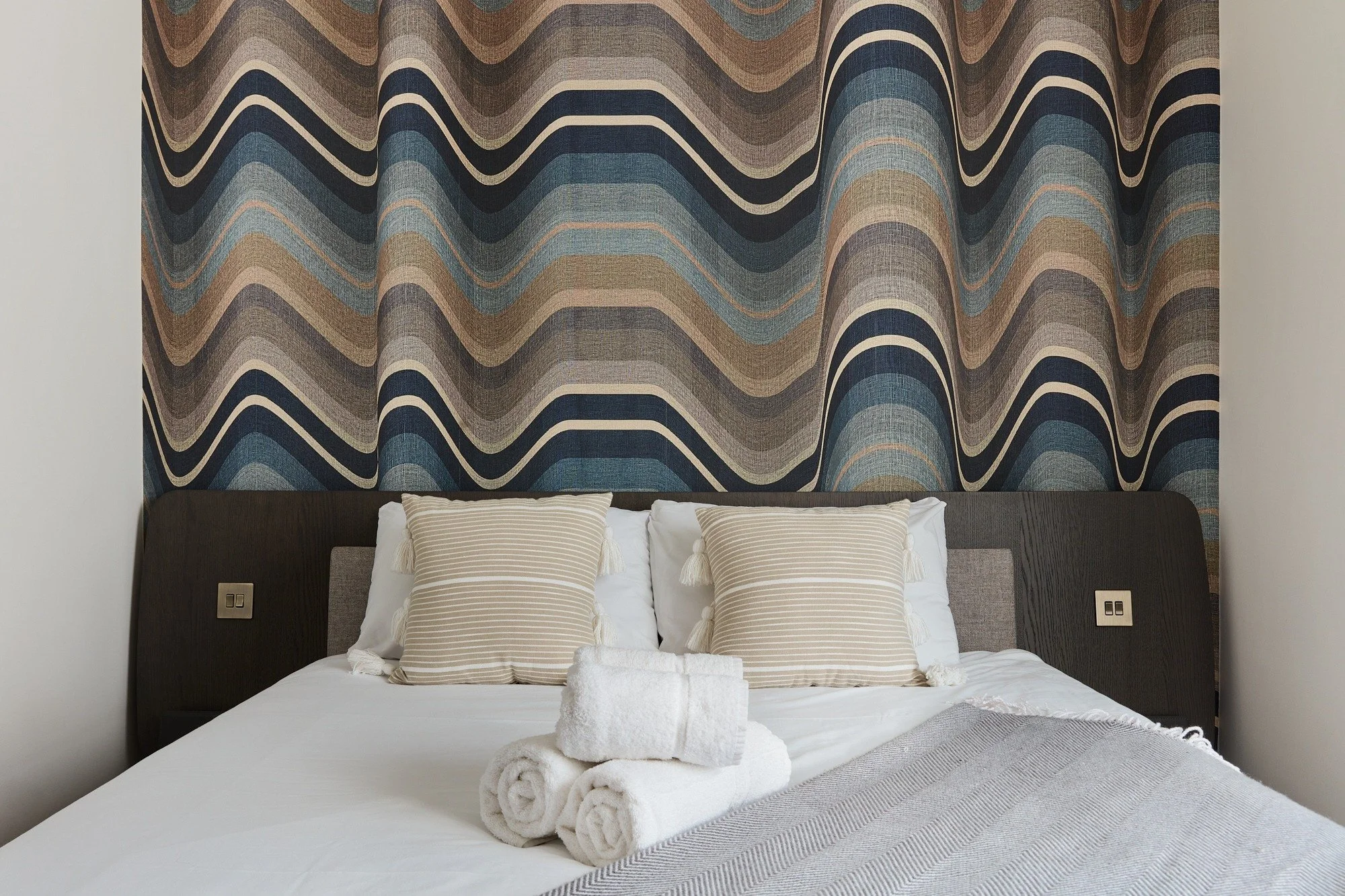 Londonart wallpaper designed to give the effect of curtains behind the bedframe
