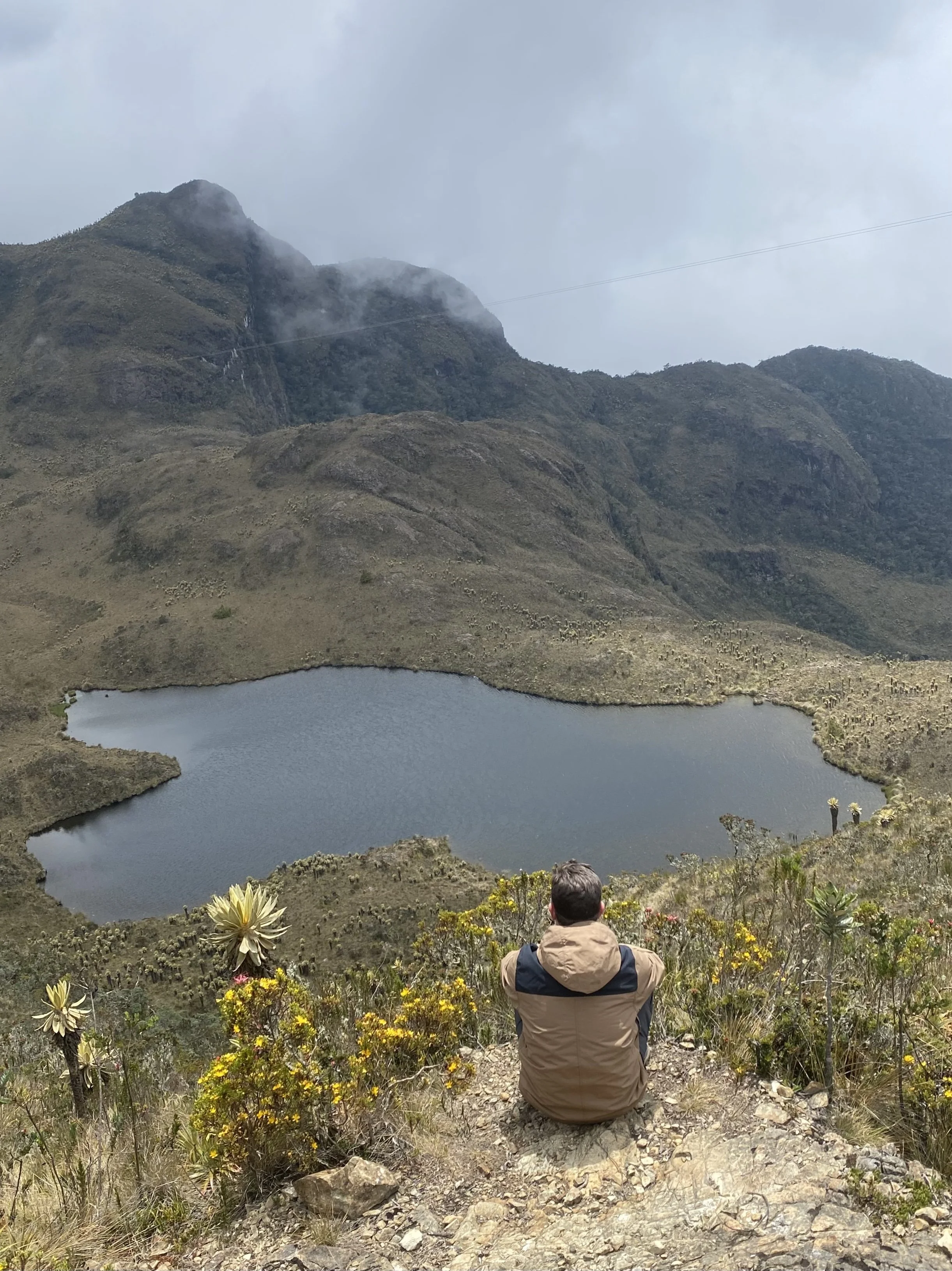 A hiker captures the peaceful beauty of Laguna Negra in Páramo de Las Domínguez, surrounded by majestic mountains and breathtaking high-altitude scenery.