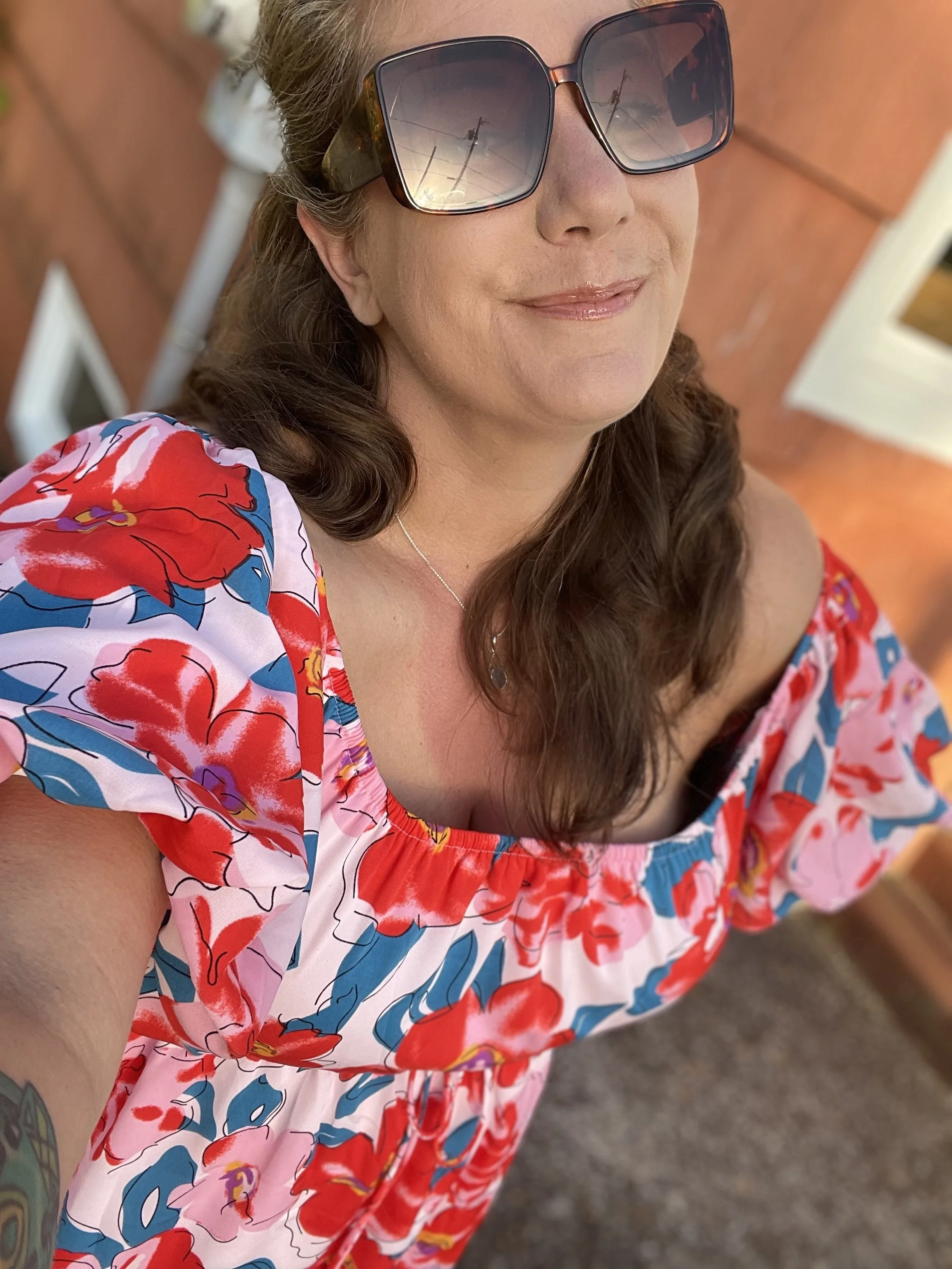 Caitlin Sumner, founder of Follow the Goose Travel, smiling in a floral dress, representing the personal care of working with a travel advisor.