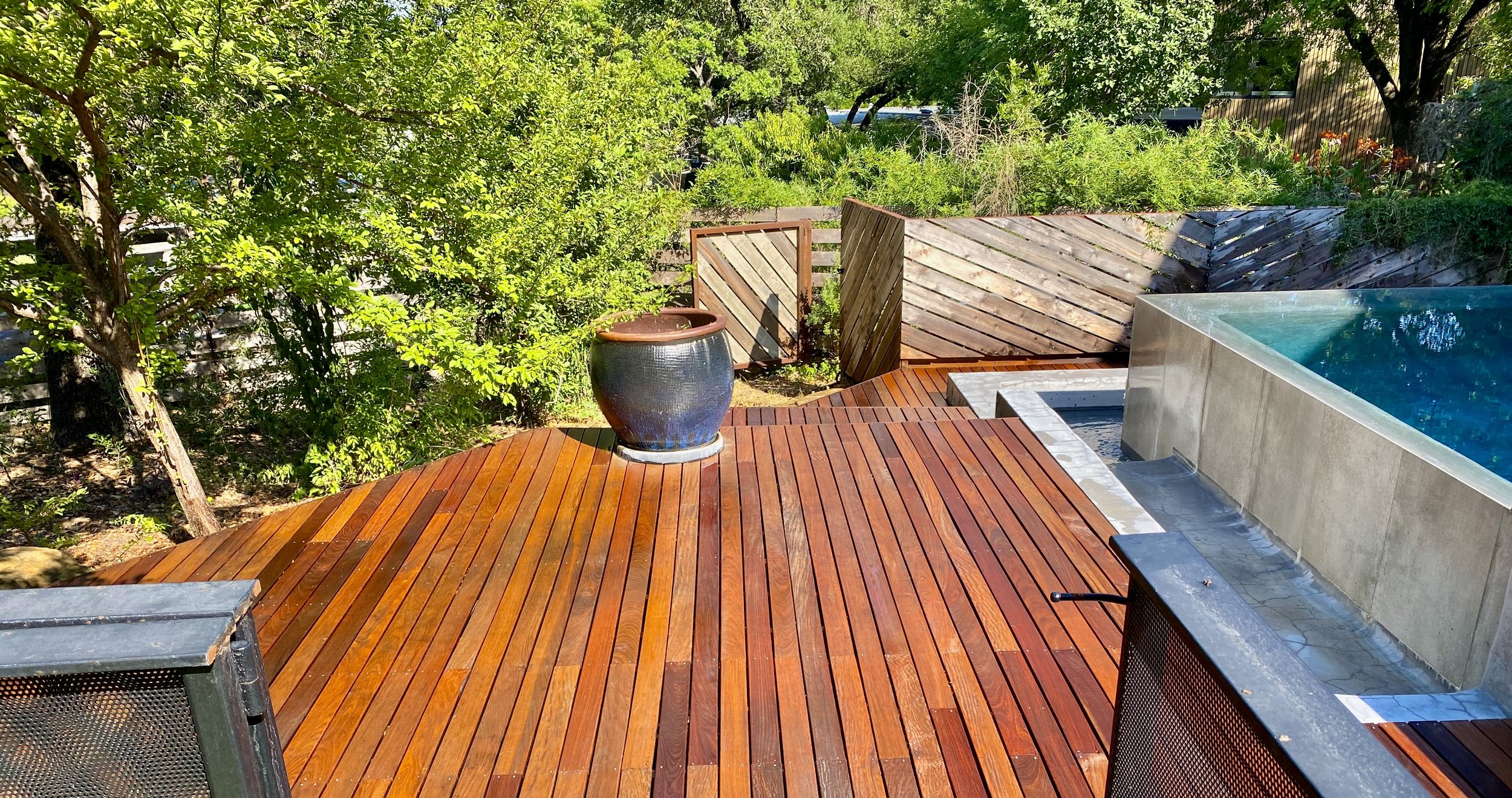 A backyard with an ipe deck built to follow the landscape surrounding our client backyard infinity pool, creating a gorgeous entrance to this modern space.