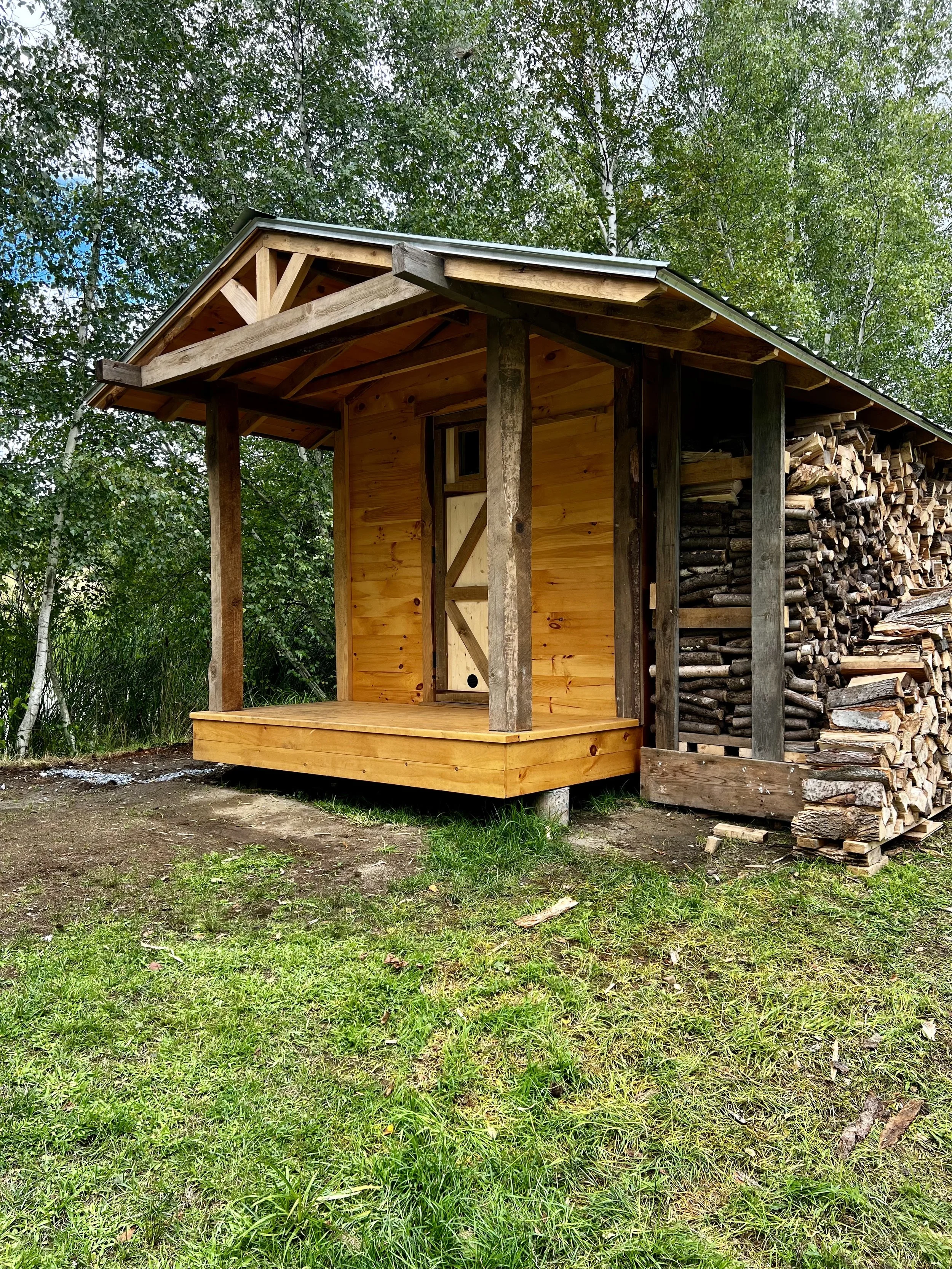Asymmetrical overhangs, integrated wood storage, and panoramic views define this sauna’s refined yet rugged architectural presence.