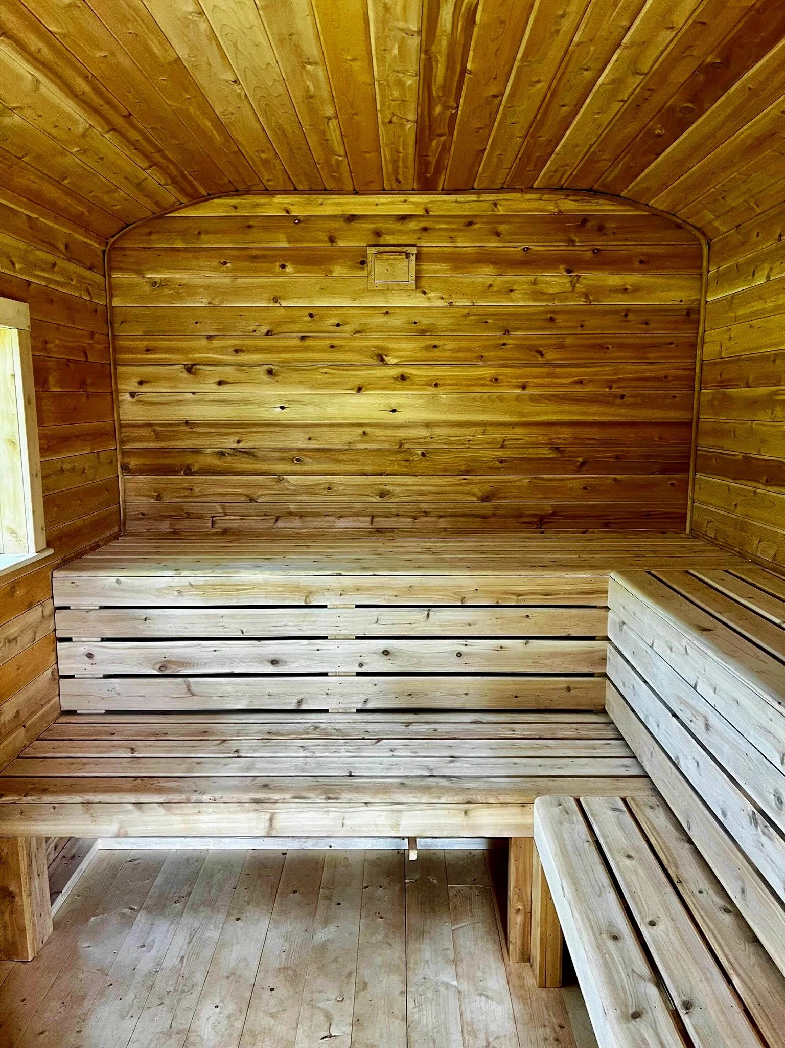 Interior detail showing hand-finished cedar surfaces and custom bench layout for maximum comfort and heat flow.