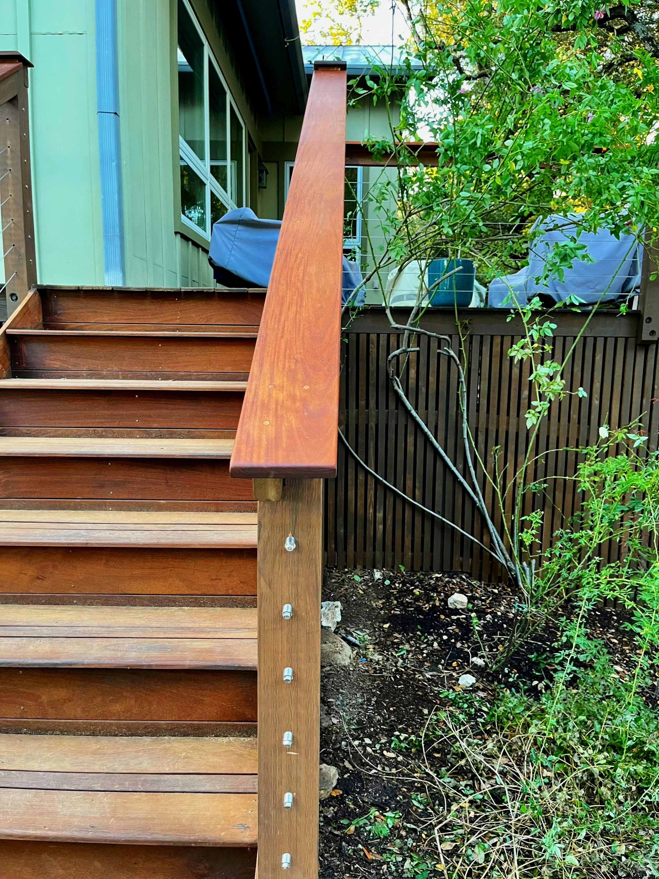 Seeking to modernize this backyard deck, we constructed a new railing with cedar posts and an Ipe railing cap with stainless steel cables.