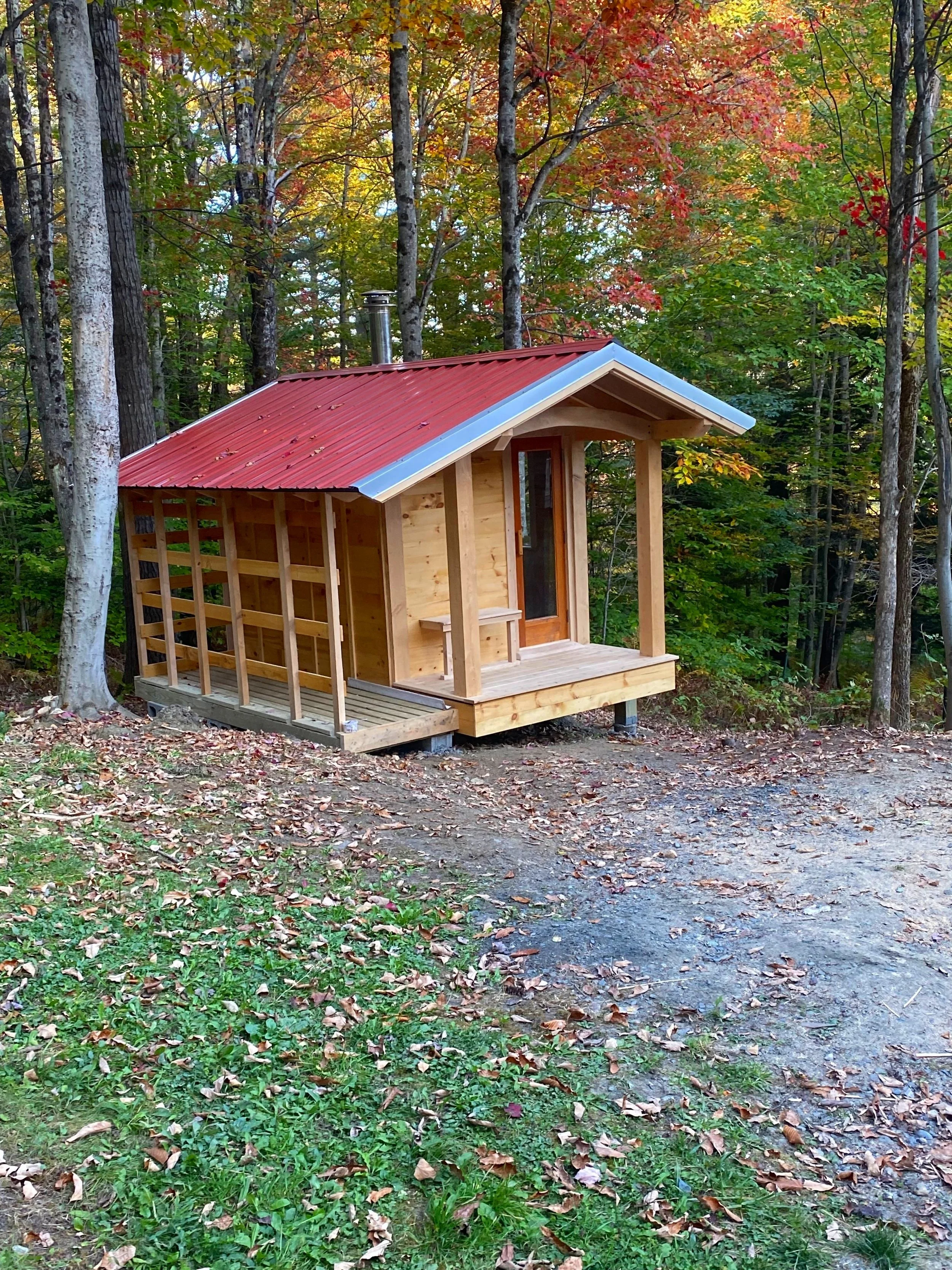 Locally sourced Hemlock and cedar define this forest-side sauna, complete with wood shed and flagstone hearth.