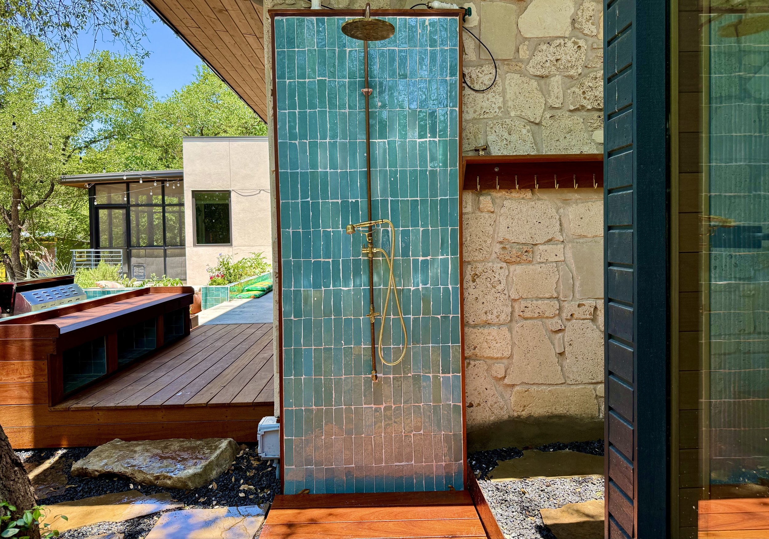 Wellness Area includes outdoor shower with hand laid tiles, custom copper fixtures & Ipe towel rack, octagonal Ipe cold plunge deck, electric sauna, and stone paver walkway.