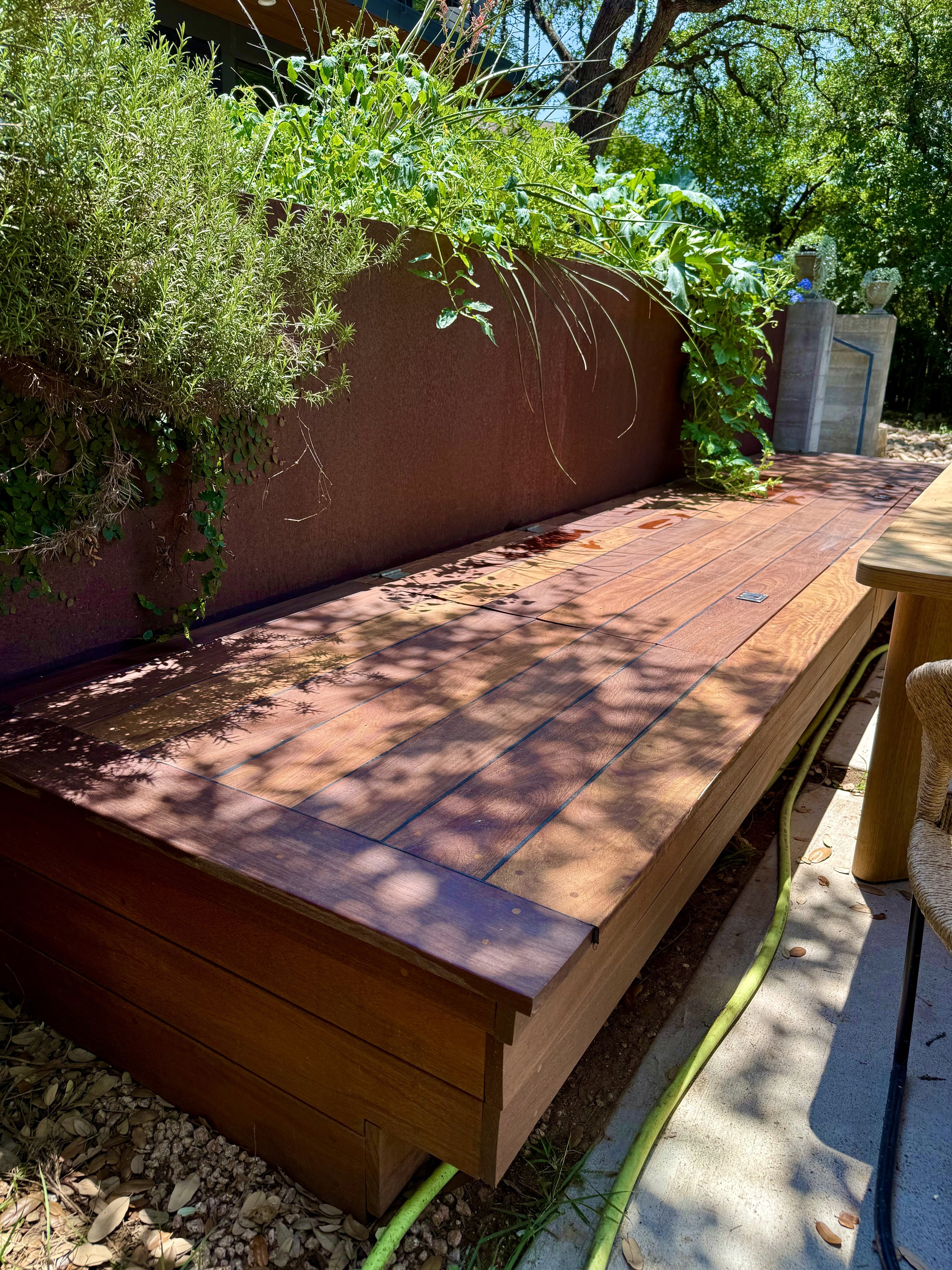 Custom Ipe Benches in both lounge and dining areas with under-seat storage hatches, planter box backrest, and cubby storage nooks finished with artisinal Moroccan tiles.