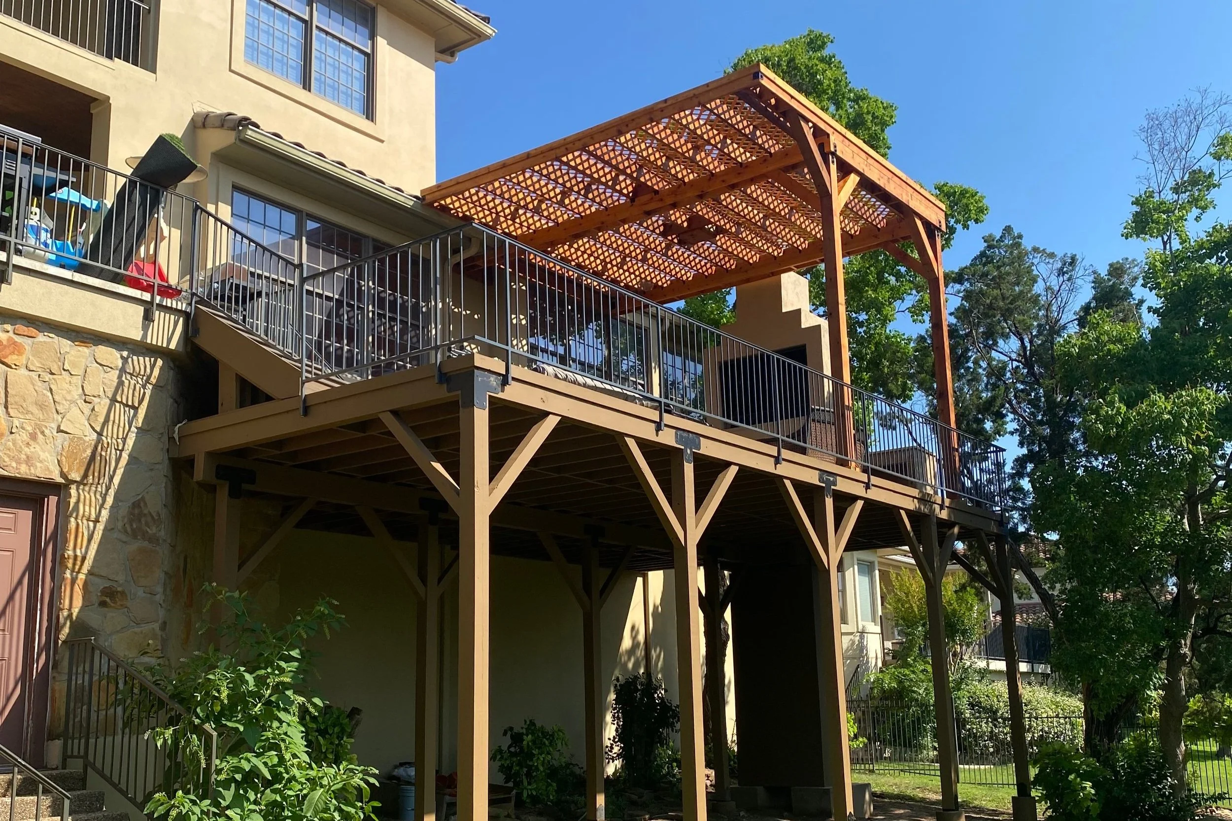 A beautifully crafted second-story deck featuring a custom cedar pergola and wood-burning fireplace, constructed of masonry and stone, for year-round outdoor enjoyment.