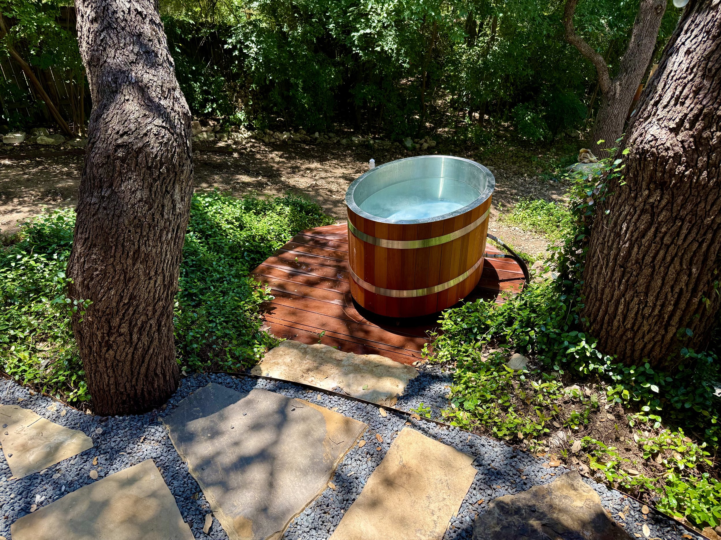 Wellness Area includes outdoor shower with hand laid tiles, custom copper fixtures & Ipe towel rack, octagonal Ipe cold plunge deck, electric sauna, and stone paver walkway.