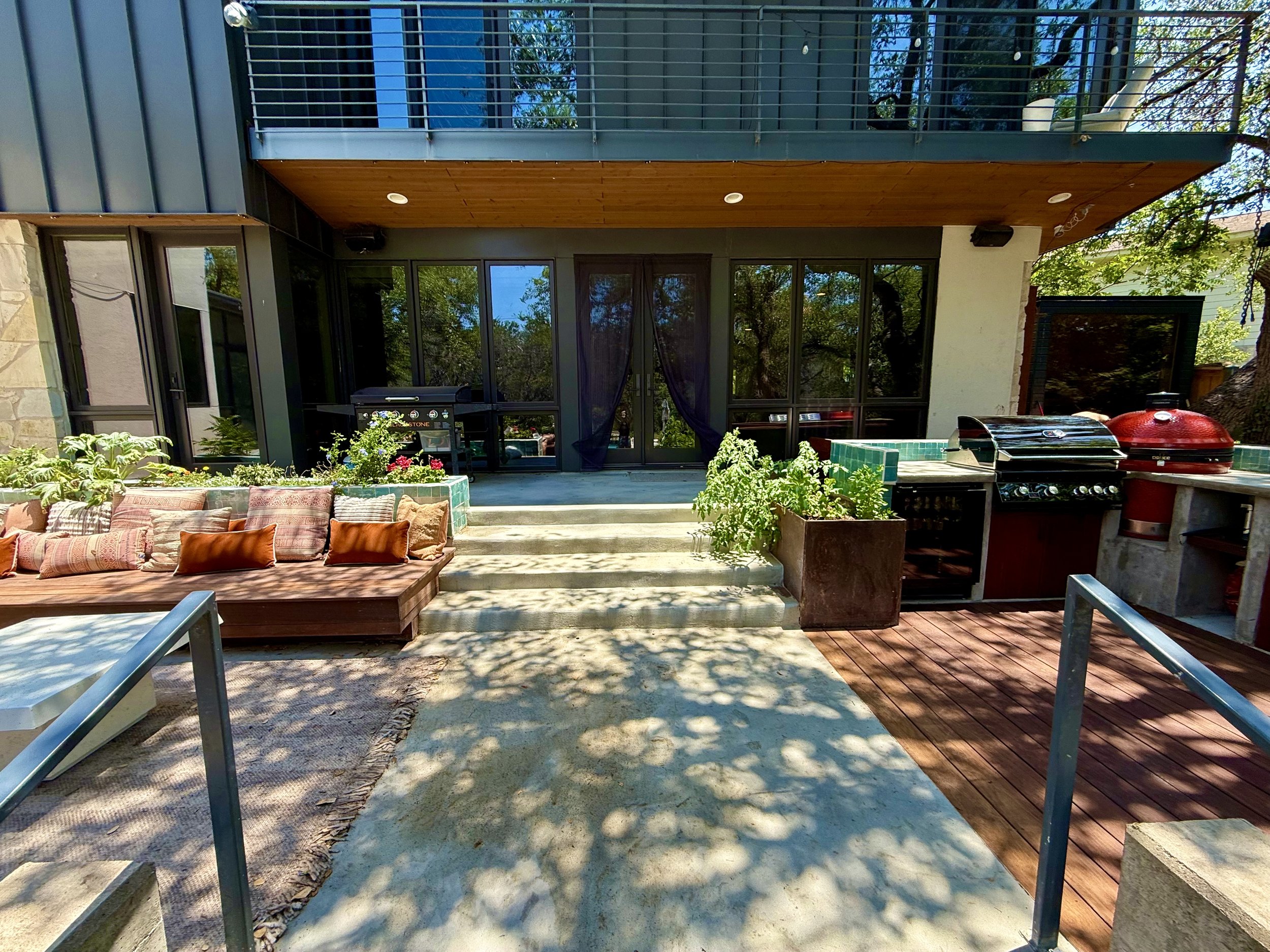 Custom Ipe Benches in both lounge and dining areas with under-seat storage hatches, planter box backrest, and cubby storage nooks finished with artisinal Moroccan tiles.