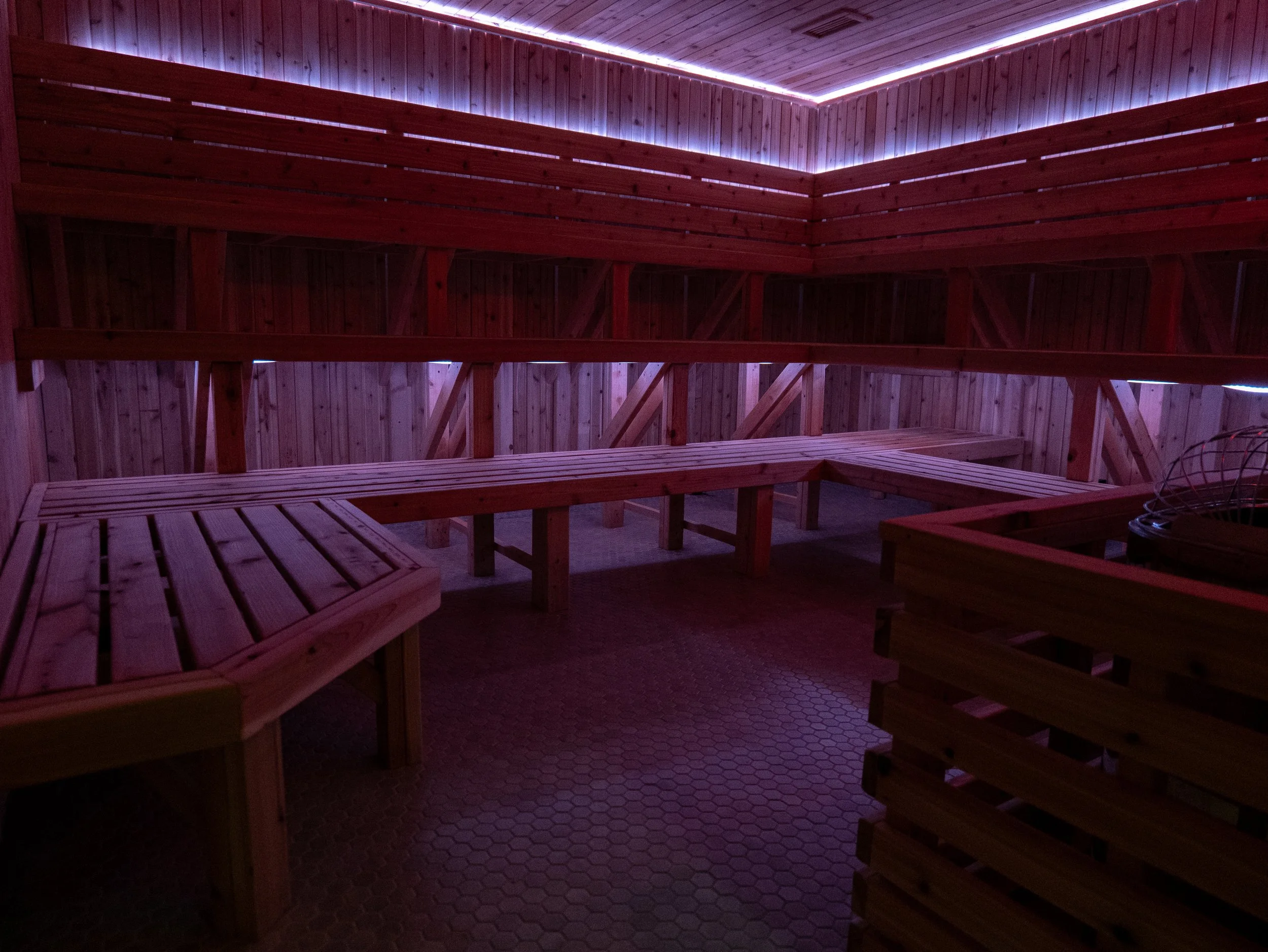 Converted from a storage room, this spacious sauna features tiled floors, LED lighting, and 30-person capacity for immersive group sessions.