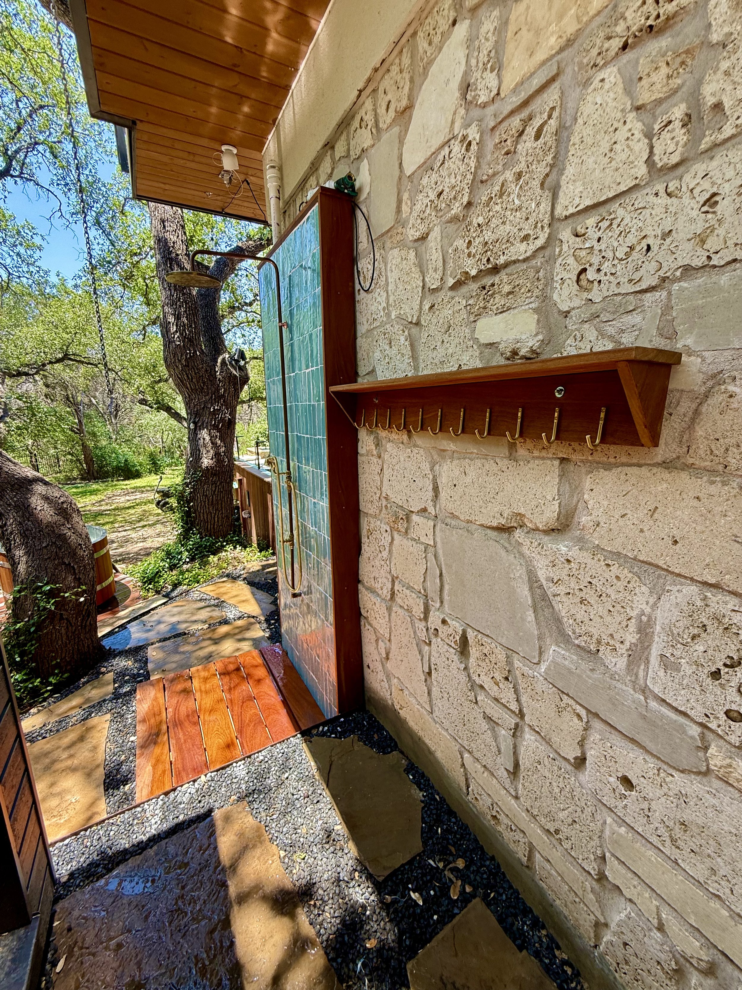 Wellness Area includes outdoor shower with hand laid tiles, custom copper fixtures & Ipe towel rack, octagonal Ipe cold plunge deck, electric sauna, and stone paver walkway.