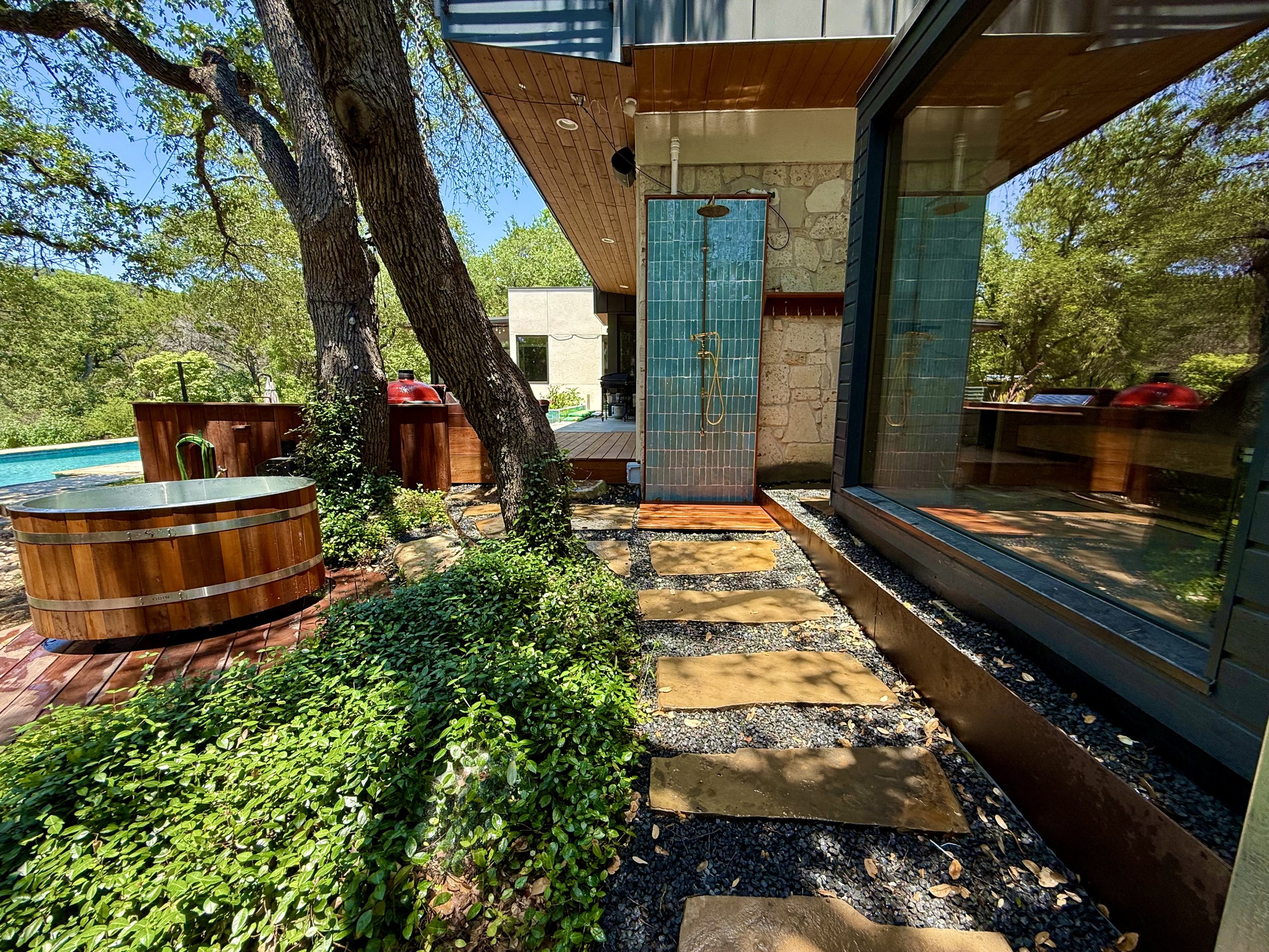 Wellness Area includes outdoor shower with hand laid tiles, custom copper fixtures & Ipe towel rack, octagonal Ipe cold plunge deck, electric sauna, and stone paver walkway.