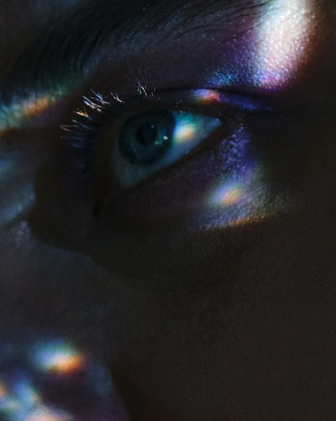 Close-up of an eye in shadow looking sideways, representing deep emotional focus in accelerated EMDR therapy.