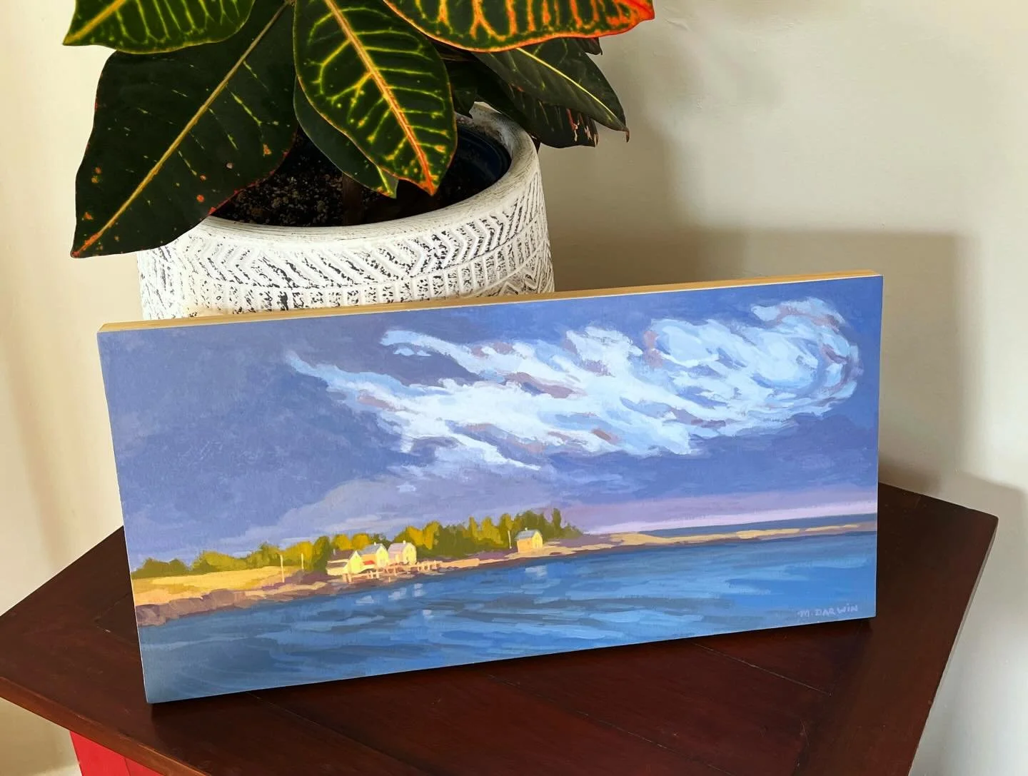 This painting was part of a trio of panoramas I created last summer capturing the last band of sunlight at the end of the day. Here, it lit up the old fish shacks lining the cove edge, as well as the tops of trees and a grassy field. The water had tu