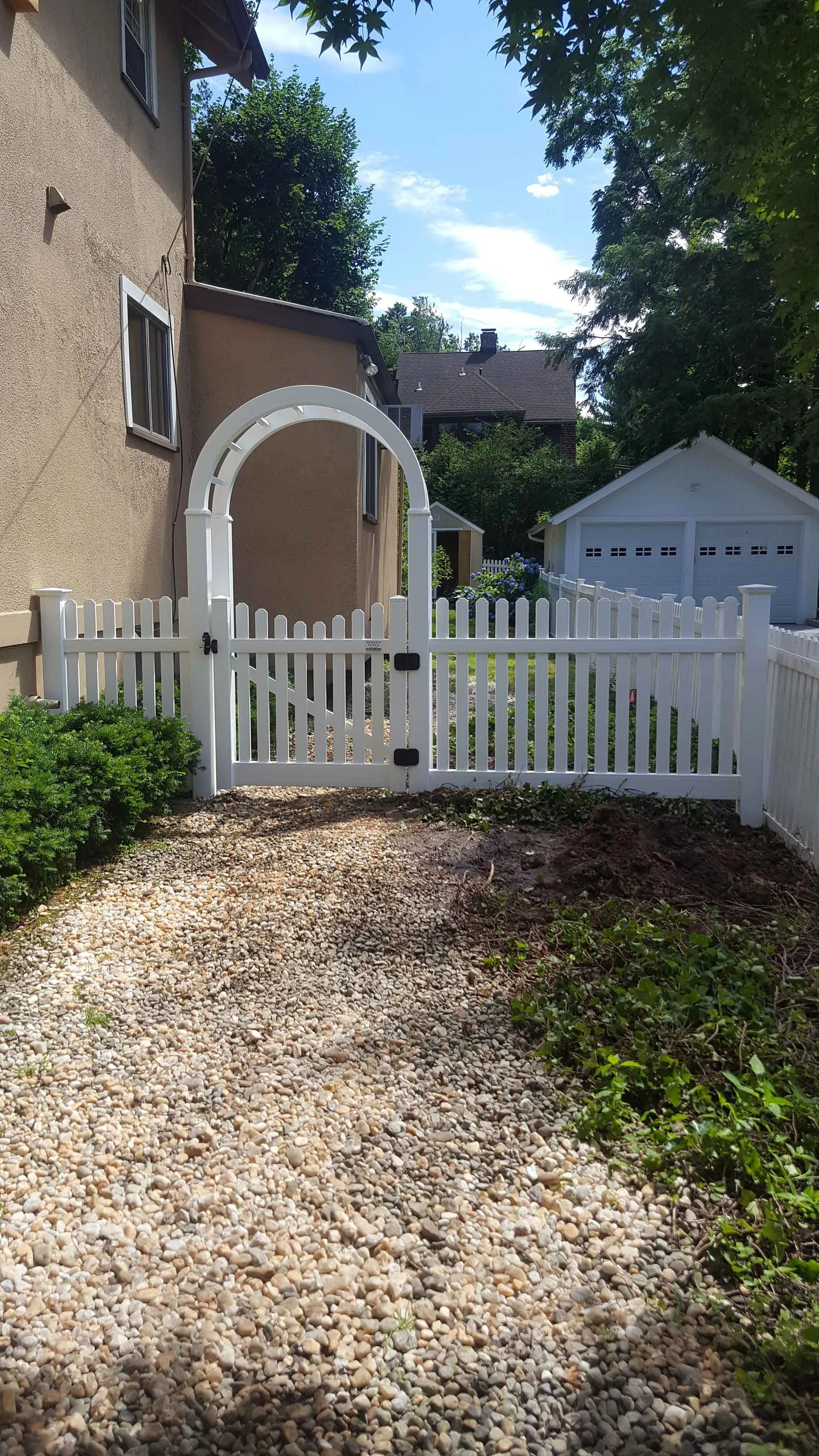 Vinyl Archway Gateway: Empire Fence's eloquent separation, featuring a charming arched door for a graceful transition.