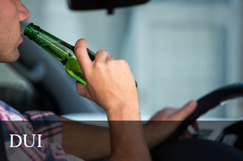 Person holding a green glass beer bottle to their mouth while sitting in a vehicle, with a blurred background and the text 'DUI' in the bottom left corner.