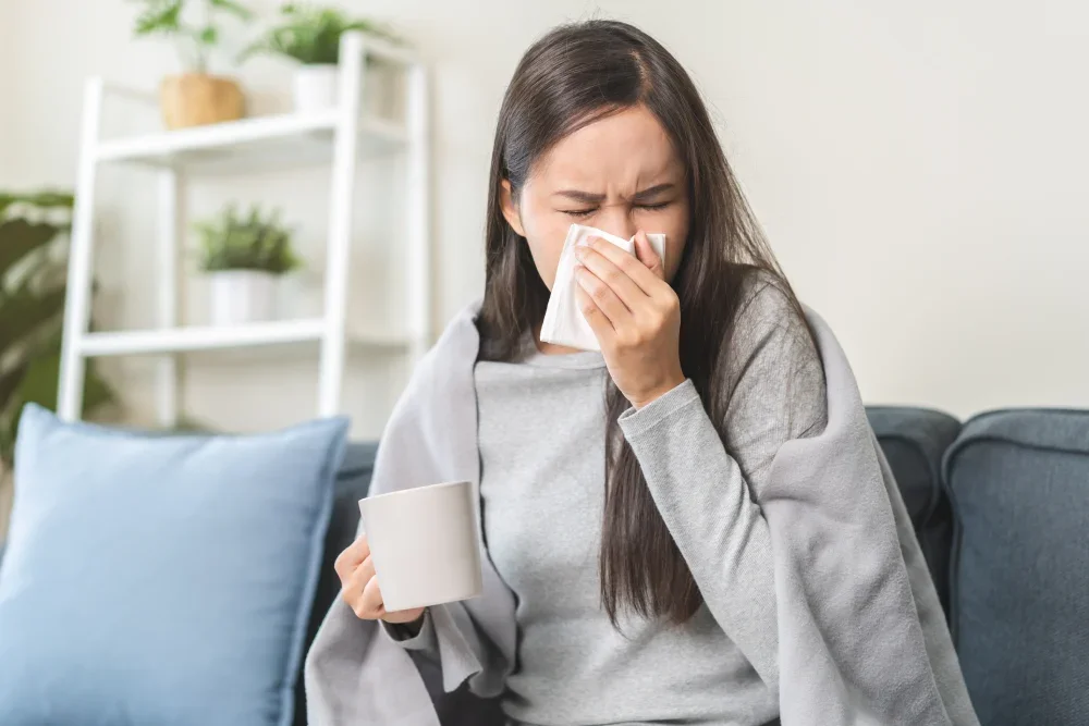 A woman suffering from a cold in an indoor setting