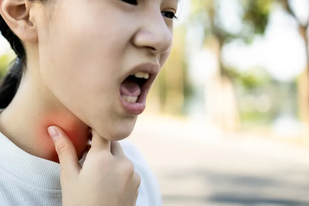: Asian girl with a sore throat