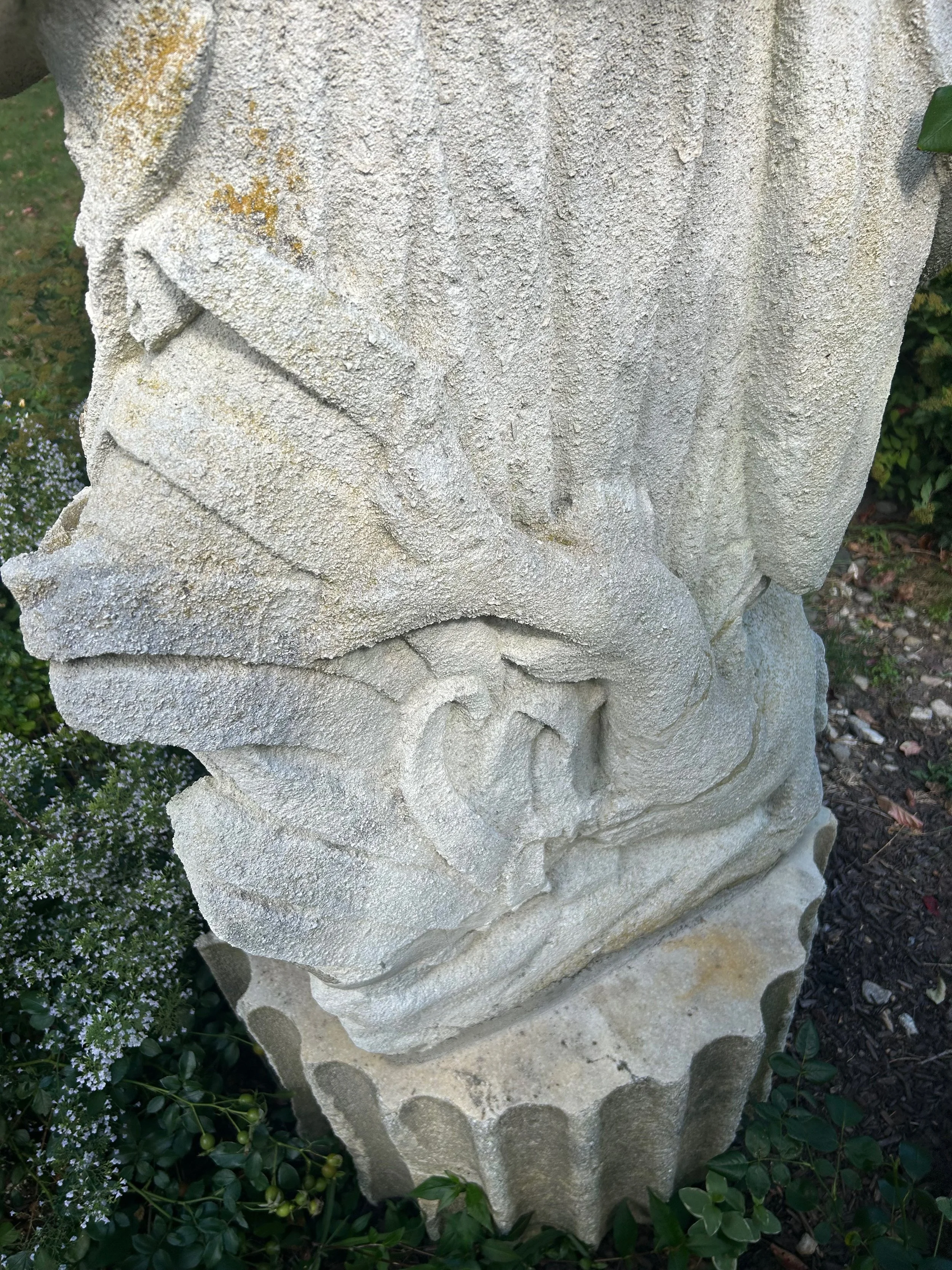 Carved attributes including a dolphin, fish, and a turtle on the base of an 18th century stone sculpture