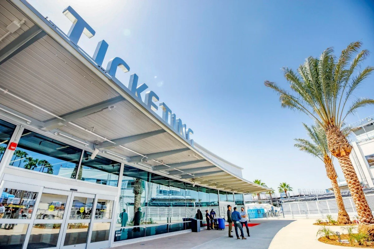 Curved entrance with canopy. Physical letters spelling Ticketing are on the front of the canopy.