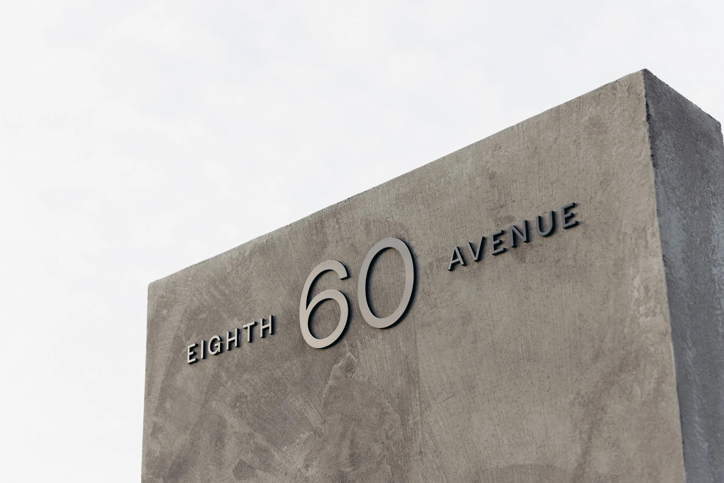 Close-up of a concrete or stone structure with the text 'The Eighth CO Avenue' in raised letters.