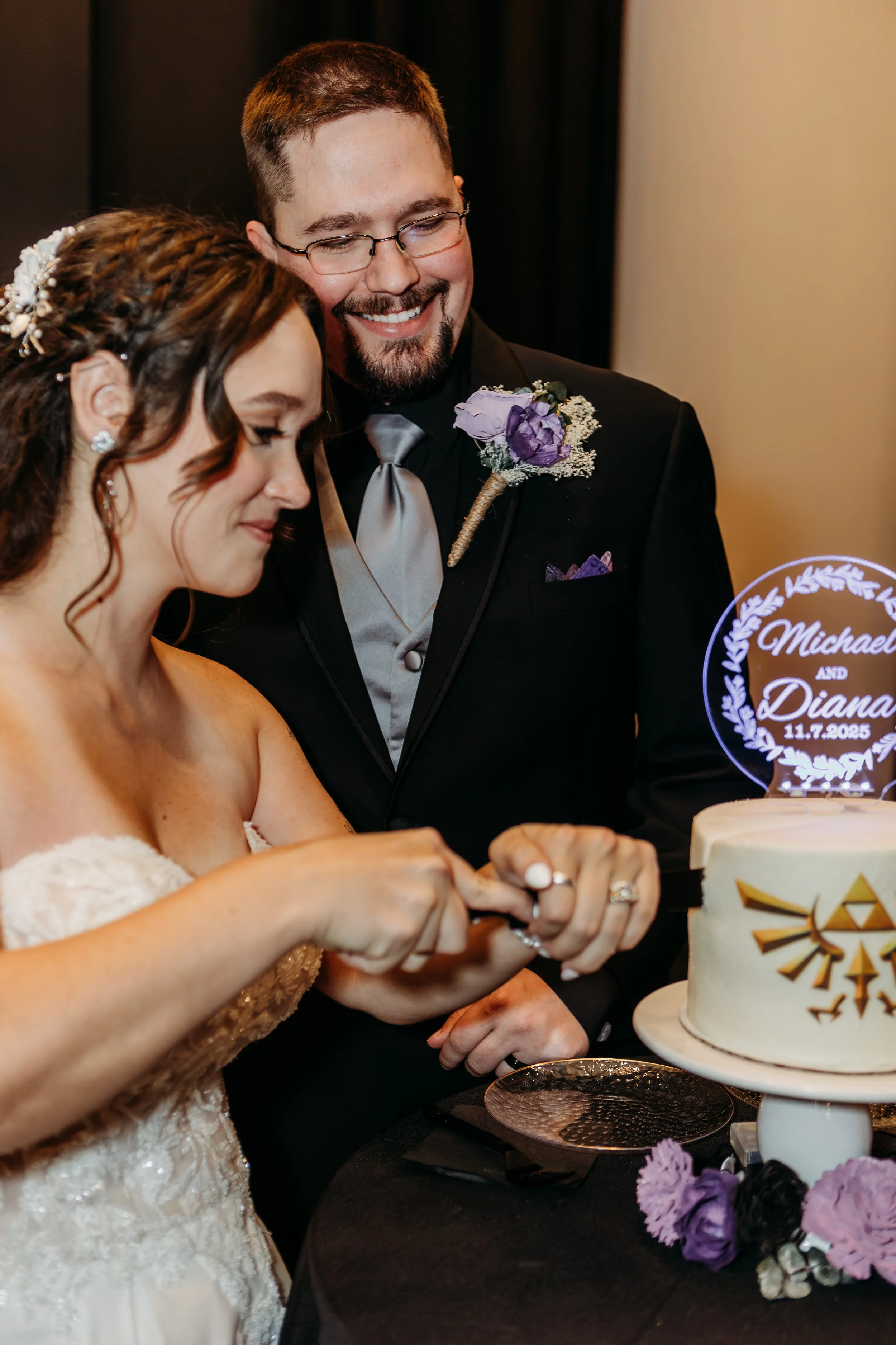 A bride and groom cutting their wedding cake together at their wedding reception.